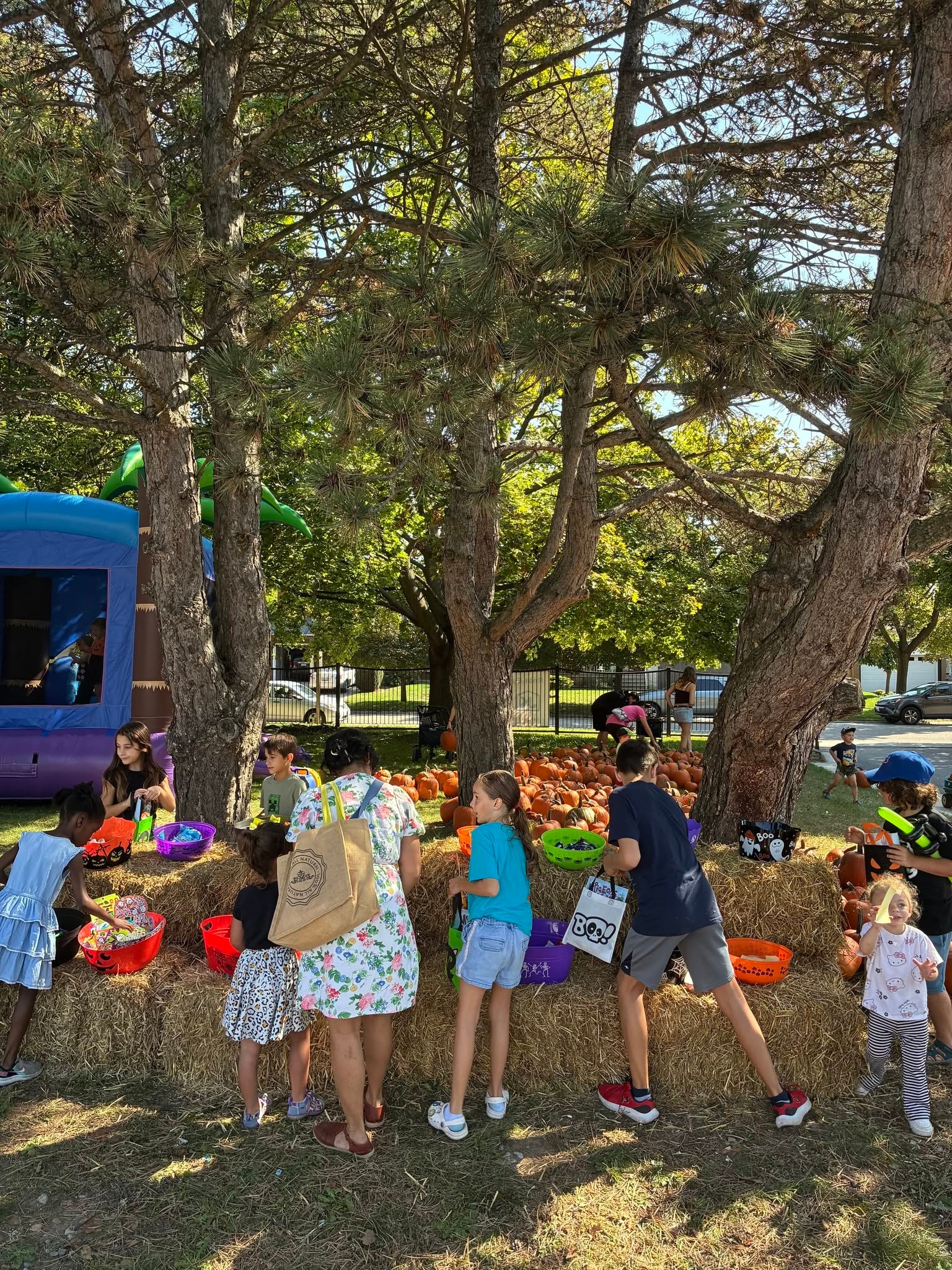 Children picking through Halloween candy on hay bales at the Pumpkin Giveaway